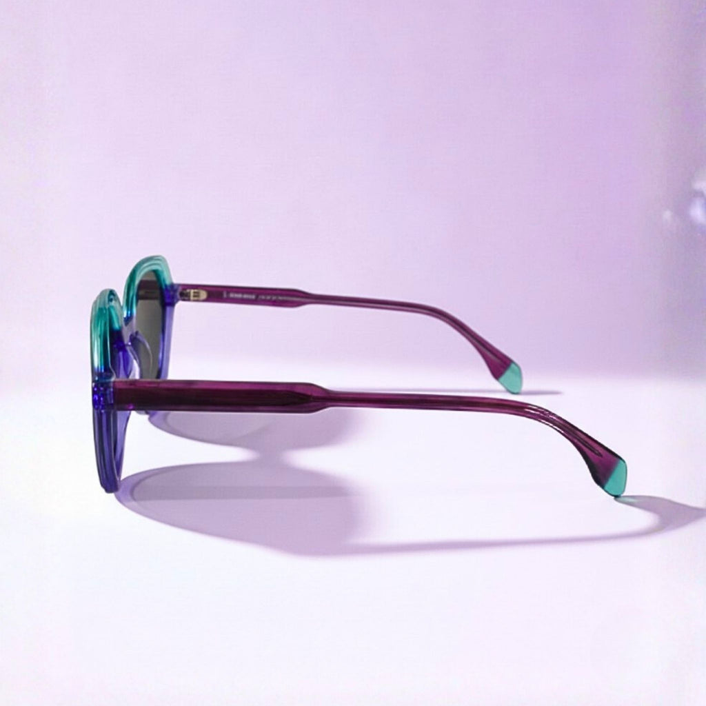 Lunettes de soleil pour femme modèle Nouméa C4 de Lumeya Suntribe, monture bicolore turquoise et violette, branches framboises, avec verres polarisés 100% anti-UV, qualité expertise opticien.