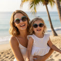 Maman et fille portant des lunettes de soleil matchy matchy du modèle Nouméa C4 de la marque Lumeya Suntribe. Ces lunettes pour femme et enfant sont dotées de verres polarisés et offrent une protection à 100% contre les rayons UV, alliant style, confort et sécurité solaire pour toute la famille lors de vacances.