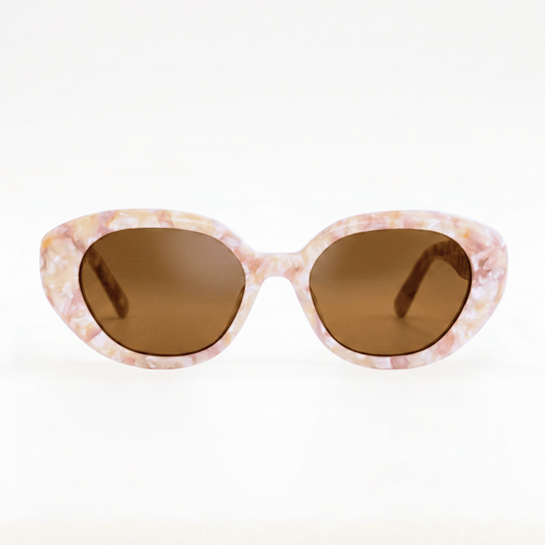 Lunettes de soleil de forme yeux de chat pour femme, monture en acétate effet nacre rose et beige pastel avec verres teintés bruns, vue de face.