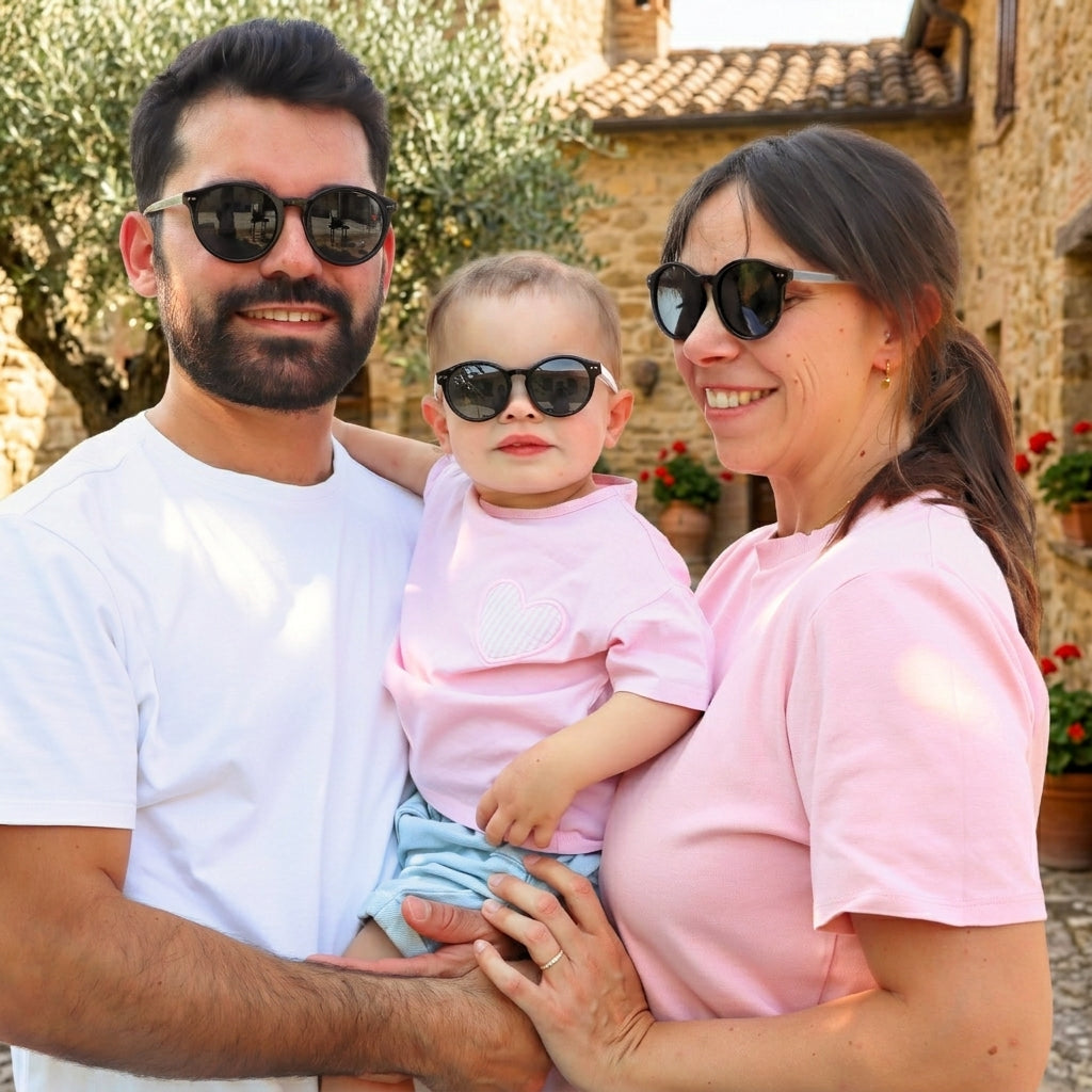 Une famille — un homme, une femme et leur jeune enfant — portant des lunettes de soleil de la marque Lumeya assorties lors d'une journée ensoleillée.
